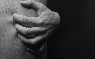 Close-up Photo Of A Person,s Hand Scratching On His Flaky Skin In Black And White